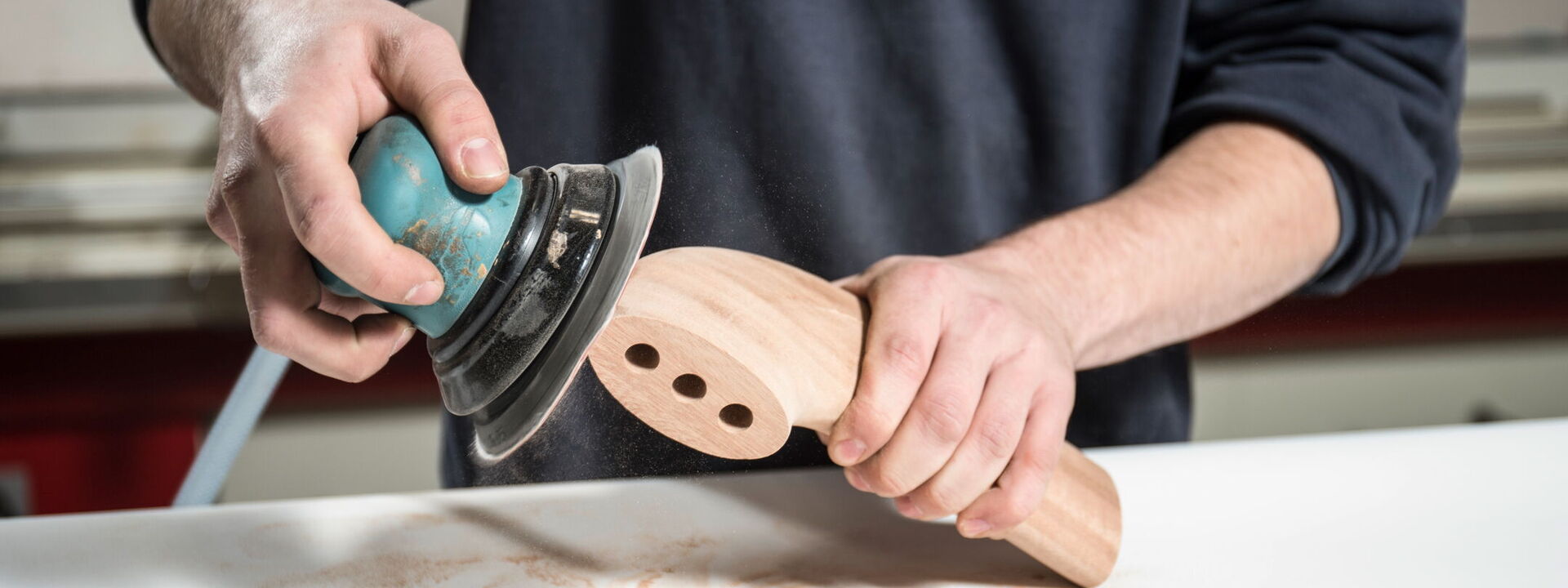 Ein Mann schleift ein Holzteil